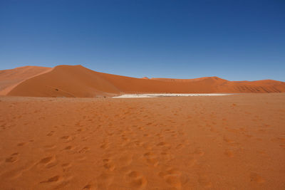 Scenic view of desert against clear blue sky