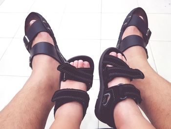 Low section of father and child wearing black sandals