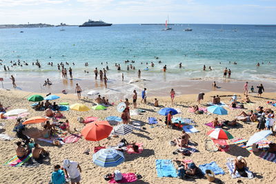 High angle view of people enjoying at beach against sky