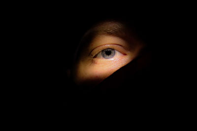 Close-up of mid adult woman against black background