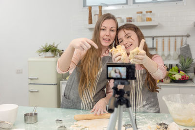 Young woman photographing while using smart phone