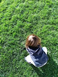 Rear view of boy relaxing on land