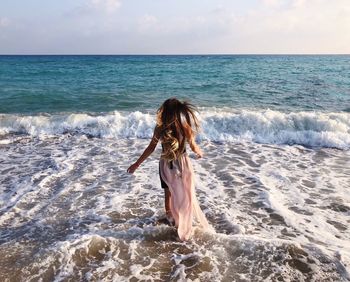 Woman at beach against sky