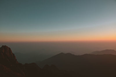 Scenic view of silhouette mountains against sky during sunset