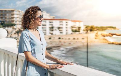 Man wearing sunglasses standing against sea