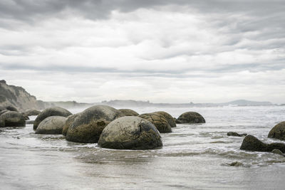 Rocks on sea shore against sky