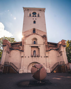 Low angle view of basketball hoop by building against sky