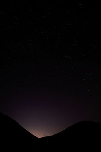 Low angle view of silhouette mountain against sky at night