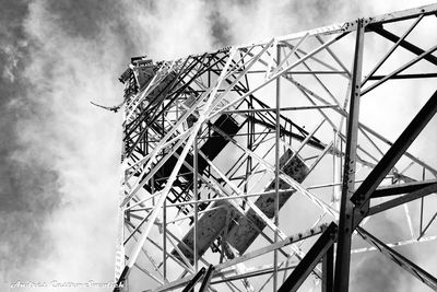 Low angle view of an old radio tower against sky in black and white