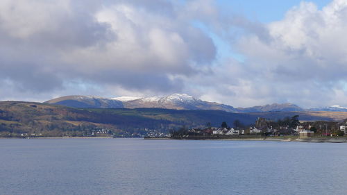 Scenic view of river and mountains against cloudy sky