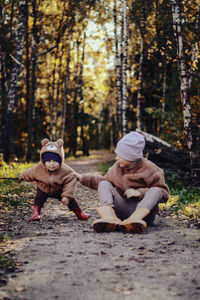 Rear view of woman sitting on rock