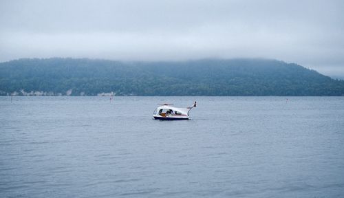 Sailboat sailing on sea against sky