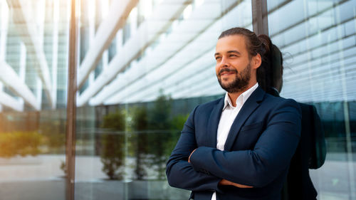 Portrait of businessman standing against wall
