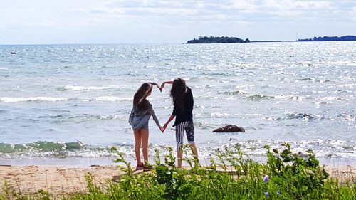 Rear view of couple standing at beach