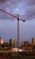 Low angle view of crane against sky