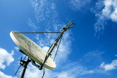 Low angle view of telephone pole against blue sky