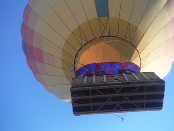 Low angle view of hot air balloons against clear blue sky