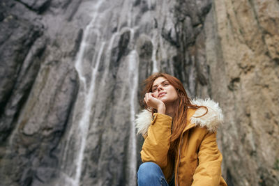 Young woman standing against rock formations