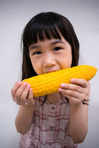 Close-up portrait of smiling girl holding fruit