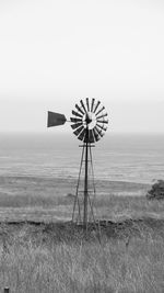 Traditional windmill on field against sky