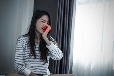 Woman with toothache at home