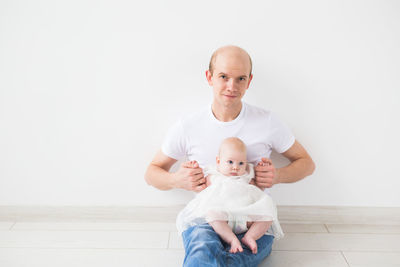 Portrait of cute smiling girl holding baby