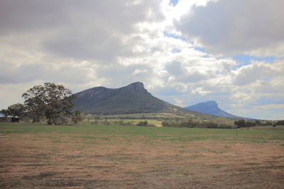 Scenic view of field and mountains against sky