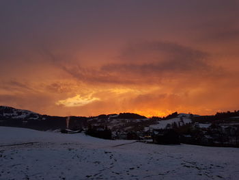 Scenic view of snowcapped landscape against sky during sunset