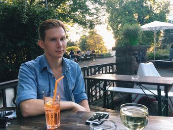 Portrait of serious man sitting by wineglass in restaurant