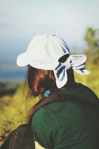 Young woman wearing cap while looking at view on mountain