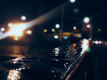 Illuminated city street during rainy season at night