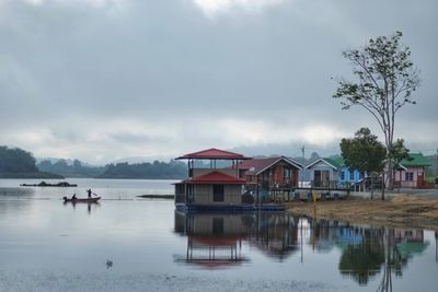 Scenic view of lake and buildings against sky