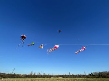 Low angle view of kites flying in sky