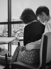 Rear view of people sitting on chair