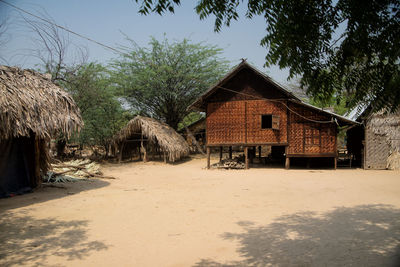 House amidst trees and buildings against sky