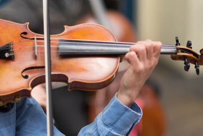 Midsection of person playing guitar at music concert