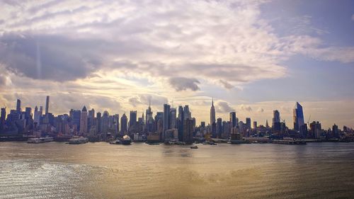 View of city buildings against cloudy sky