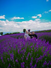 Senior couple holding flower while standing on lavender field