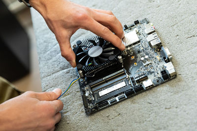 Midsection of man repairing mother board