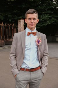 Portrait of groom in casual brown suit, white shirt and bow tie. weeding suit