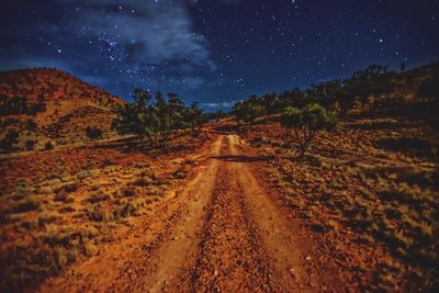 Road amidst landscape against sky at night