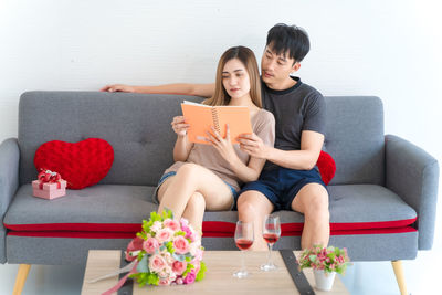 Young woman sitting on sofa at home