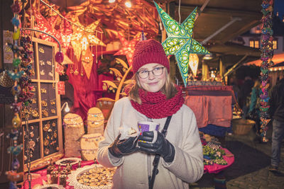 Young woman standing in market during christmas