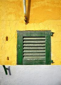 View of green window of yellow building