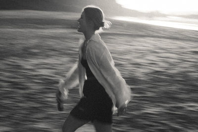 Rear view of woman running at the beach