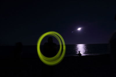 Light painting on beach against sky at night