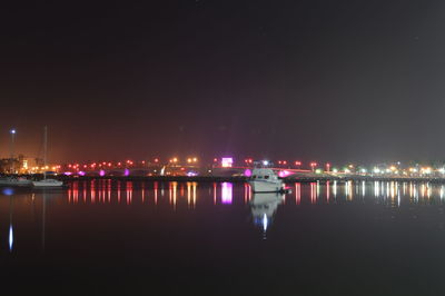Illuminated boats in river at night