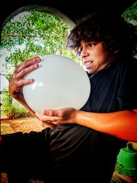 Portrait of young man holding balloons