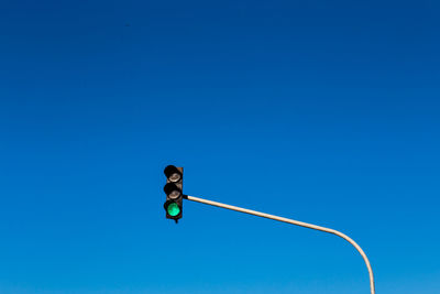 Low angle view of street light against blue sky