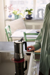 Woman preparing coffee on electric stove burner